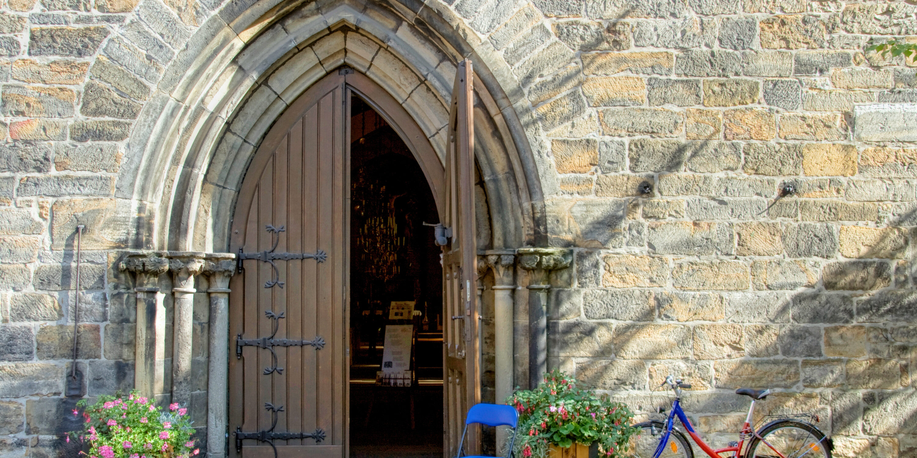 Kirche mit offenem Portal und Fahrrad
