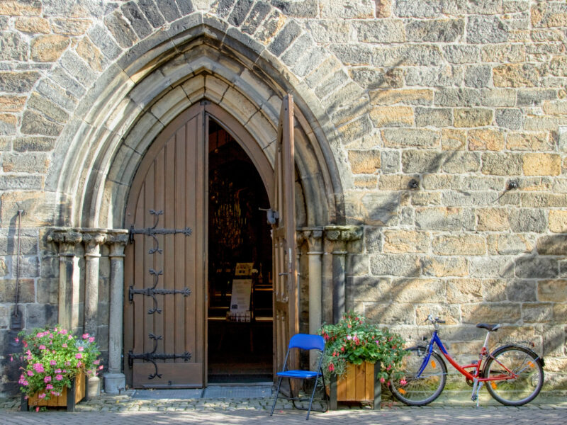 Kirche mit offenem Portal und Fahrrad